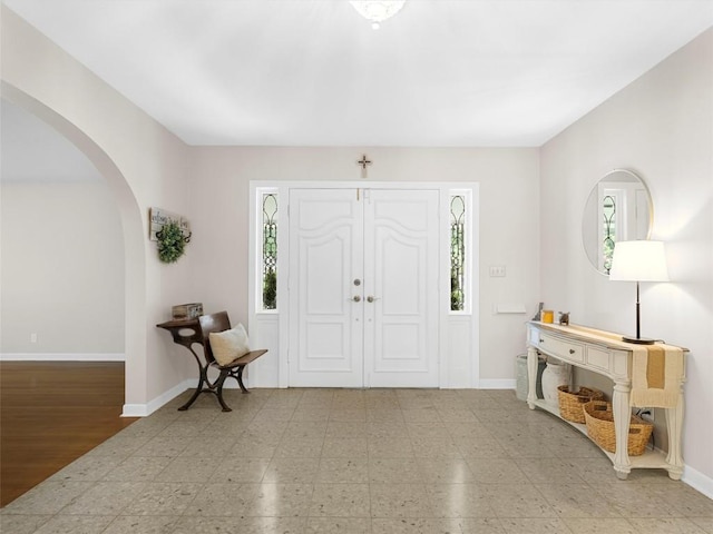 foyer featuring arched walkways and plenty of natural light