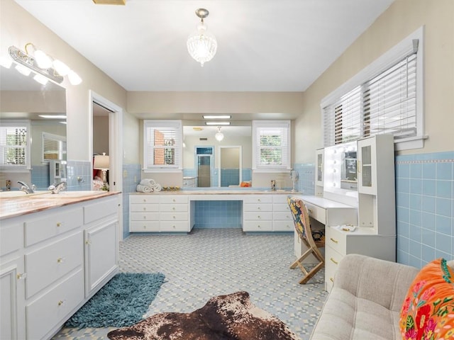 bathroom featuring plenty of natural light, tile walls, vanity, and a wainscoted wall