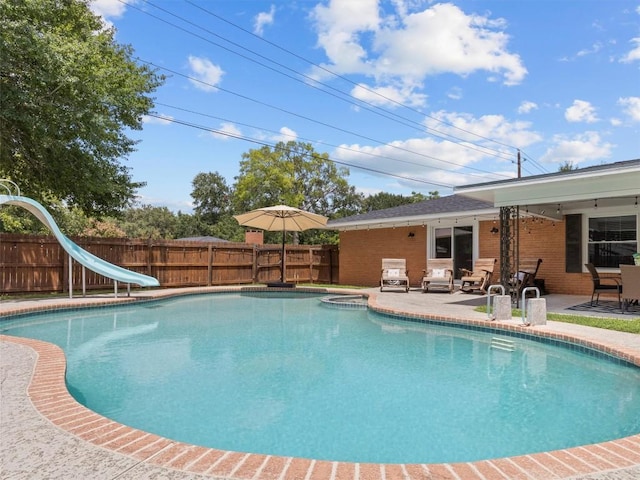 view of pool featuring a water slide, a patio area, and a fenced backyard