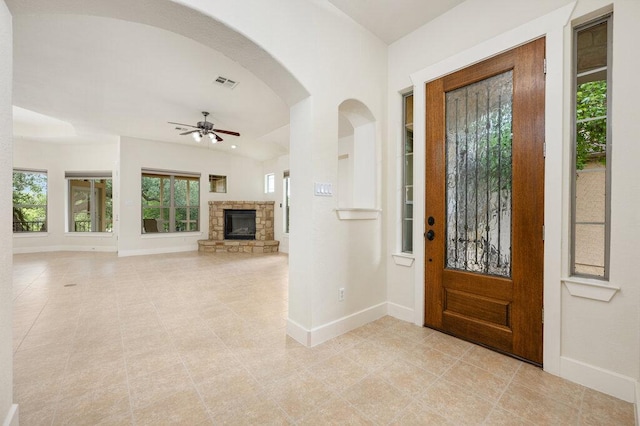 105 Outcrop View Ln, Austin, TX 78738 - entryway with ceiling fan, a stone fireplace, light tile patterned floors, and arched walkways