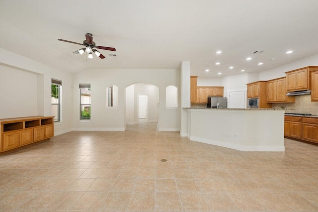 105 Outcrop View Ln, Austin, TX 78738 - unfurnished living room with arched walkways, a ceiling fan, recessed lighting, light tile patterned flooring, and vaulted ceiling