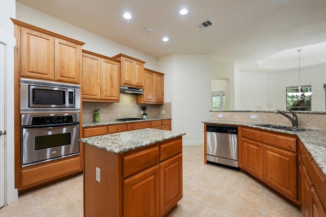 105 Outcrop View Ln, Austin, TX 78738 - kitchen with appliances with stainless steel finishes, under cabinet range hood, decorative backsplash, light stone counters, and recessed lighting
