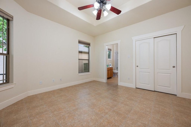 105 Outcrop View Ln, Austin, TX 78738 - unfurnished bedroom with a tray ceiling, ensuite bath, and a closet