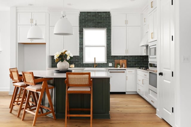 352 Moonlit Stream Pass, Dripping Springs, TX 78620 - kitchen featuring white appliances, a center island, white cabinets, tasteful backsplash, and light countertops