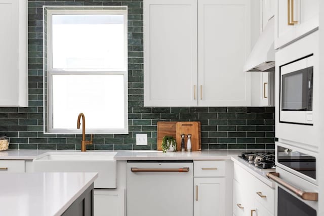 352 Moonlit Stream Pass, Dripping Springs, TX 78620 - kitchen featuring white appliances, white cabinetry, under cabinet range hood, and light countertops