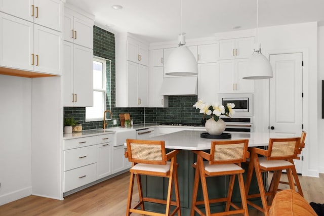 352 Moonlit Stream Pass, Dripping Springs, TX 78620 - kitchen with white cabinetry, tasteful backsplash, and light countertops