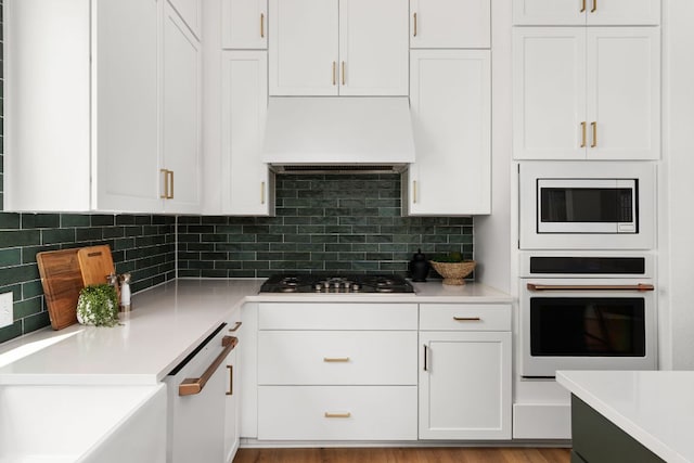 352 Moonlit Stream Pass, Dripping Springs, TX 78620 - kitchen with oven, gas cooktop, custom range hood, and white cabinets