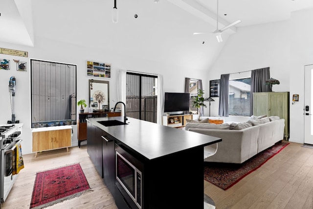 5509 Clay Ave Unit 2, Austin, TX 78756 - kitchen with appliances with stainless steel finishes, light wood-type flooring, high vaulted ceiling, a center island with sink, and beam ceiling