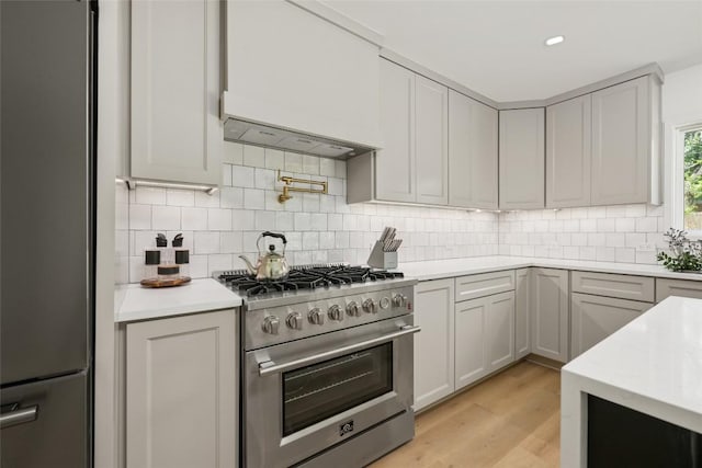 1101 Floradale Dr, Austin, TX 78753 - kitchen featuring stainless steel appliances, tasteful backsplash, light wood-type flooring, and extractor fan