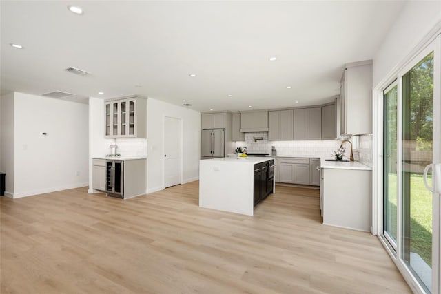 1101 Floradale Dr, Austin, TX 78753 - kitchen featuring high end fridge, beverage cooler, decorative backsplash, a center island, and gray cabinets