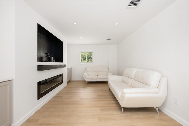 1101 Floradale Dr, Austin, TX 78753 - living area featuring light wood-style floors, a glass covered fireplace, and recessed lighting