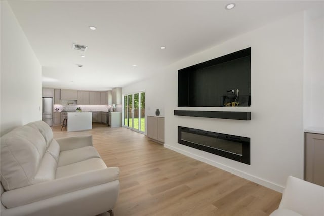 1101 Floradale Dr, Austin, TX 78753 - living room with recessed lighting, light wood-style flooring, and a glass covered fireplace
