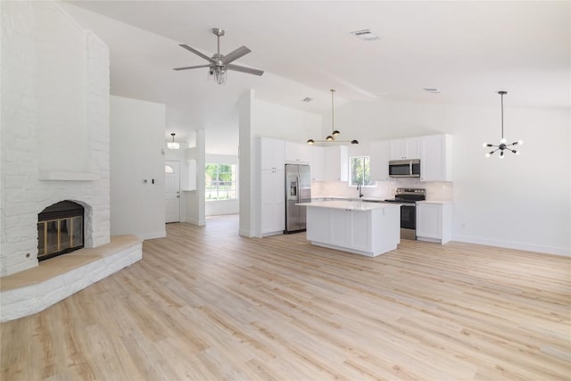 2502 W Messick Loop, Round Rock, TX 78681 - kitchen with stainless steel appliances, open floor plan, light countertops, and high vaulted ceiling