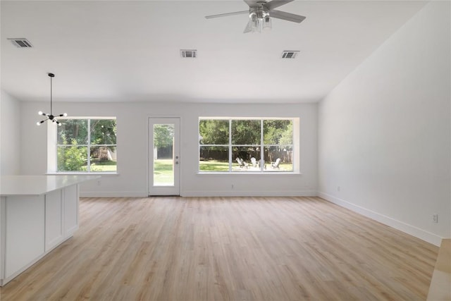 2502 W Messick Loop, Round Rock, TX 78681 - unfurnished living room with healthy amount of natural light, light wood-style floors, a chandelier, and a ceiling fan