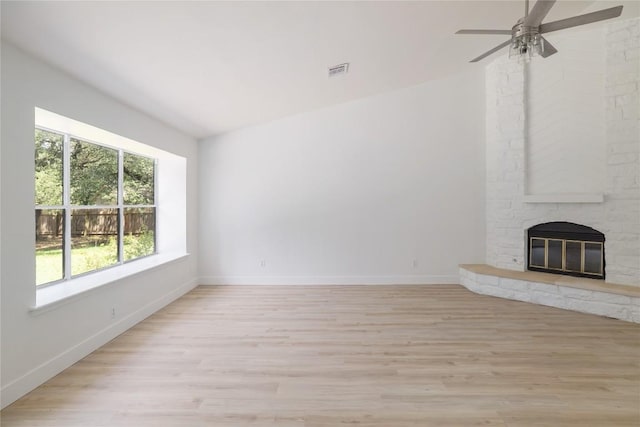 2502 W Messick Loop, Round Rock, TX 78681 - unfurnished living room with light wood finished floors, a ceiling fan, and a stone fireplace