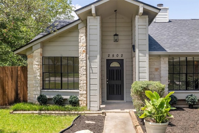 2502 W Messick Loop, Round Rock, TX 78681 - doorway to property featuring a shingled roof and stone siding