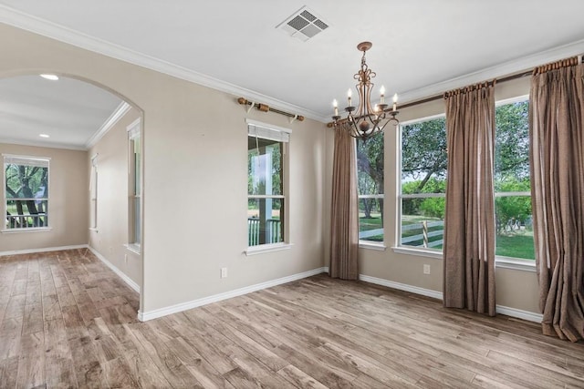 15020 Hero Way W, Leander, TX 78641 - spare room featuring arched walkways, crown molding, a chandelier, wood finished floors, and healthy amount of natural light