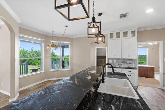 15020 Hero Way W, Leander, TX 78641 - kitchen with light wood finished floors, plenty of natural light, decorative backsplash, and crown molding