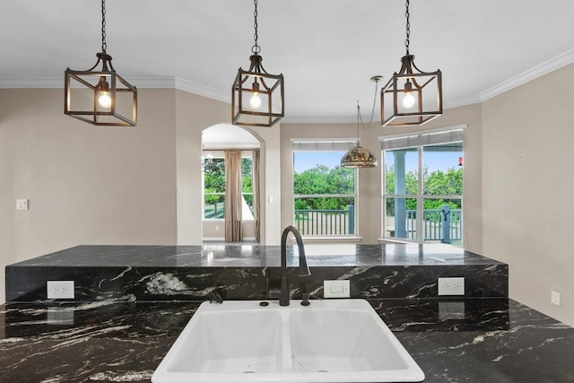 15020 Hero Way W, Leander, TX 78641 - kitchen with healthy amount of natural light, crown molding, arched walkways, and hanging light fixtures