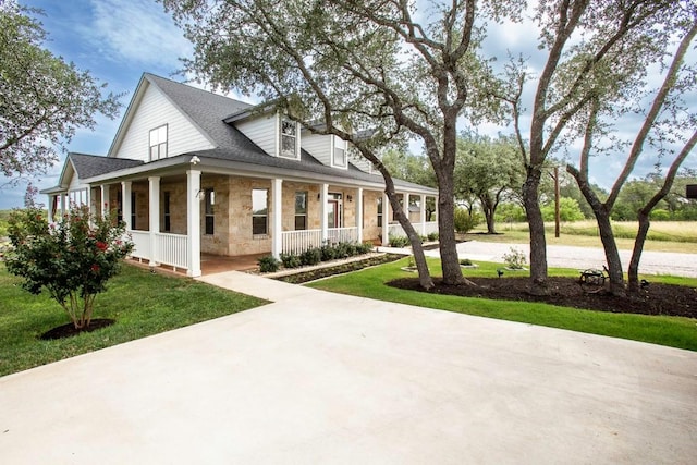 15020 Hero Way W, Leander, TX 78641 - view of front of property with stone siding, covered porch, a front lawn, and a shingled roof