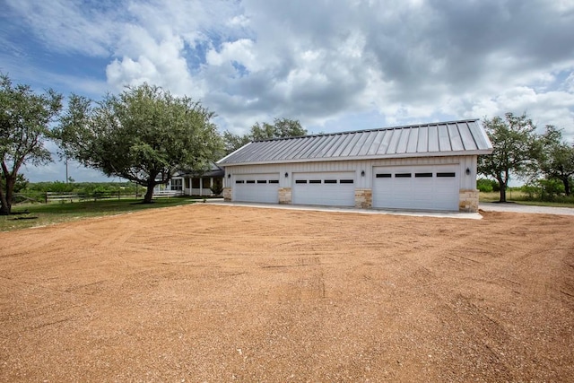 15020 Hero Way W, Leander, TX 78641 - view of side of home with a metal roof, stone siding, a garage, and board and batten siding