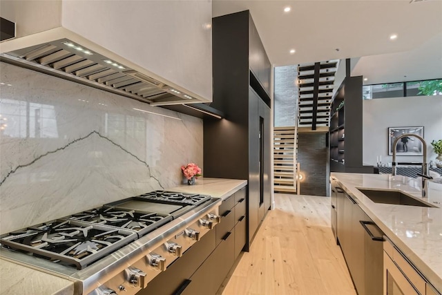 1315 W 9th St Unit B, Austin, TX 78703 - kitchen with stainless steel gas cooktop, premium range hood, light wood-style floors, light stone countertops, and decorative backsplash
