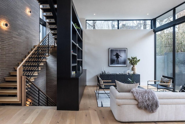 1315 W 9th St Unit B, Austin, TX 78703 - living room featuring stairs, healthy amount of natural light, a towering ceiling, wood finished floors, and brick wall