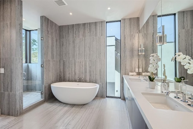 1315 W 9th St Unit B, Austin, TX 78703 - bathroom featuring tile walls, a soaking tub, double vanity, and a stall shower