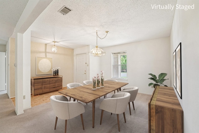 12404 Wycliff Ln, Austin, TX 78727 - dining area with light colored carpet, a textured ceiling, and a chandelier