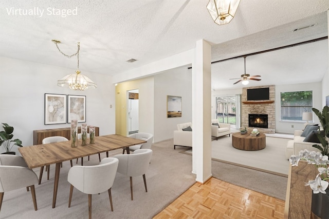 12404 Wycliff Ln, Austin, TX 78727 - dining room featuring a textured ceiling, a stone fireplace, a ceiling fan, a chandelier, and light carpet