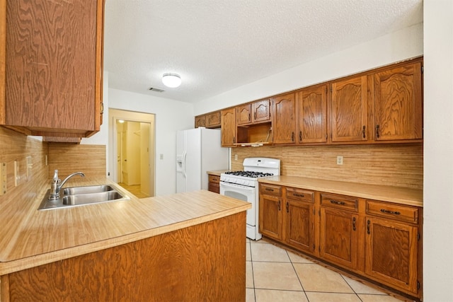 12404 Wycliff Ln, Austin, TX 78727 - kitchen with white appliances, backsplash, light countertops, light tile patterned flooring, and a textured ceiling