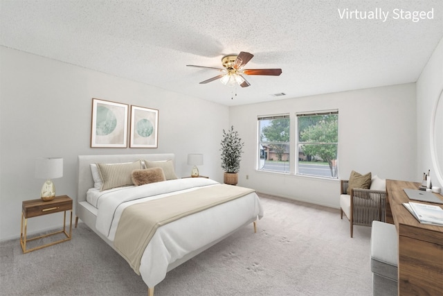 12404 Wycliff Ln, Austin, TX 78727 - bedroom featuring light colored carpet, a textured ceiling, and a ceiling fan