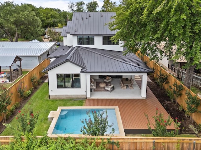 1703 Madison, Austin, TX 78757 - back of house featuring a standing seam roof, a metal roof, a deck, a fenced backyard, and stucco siding