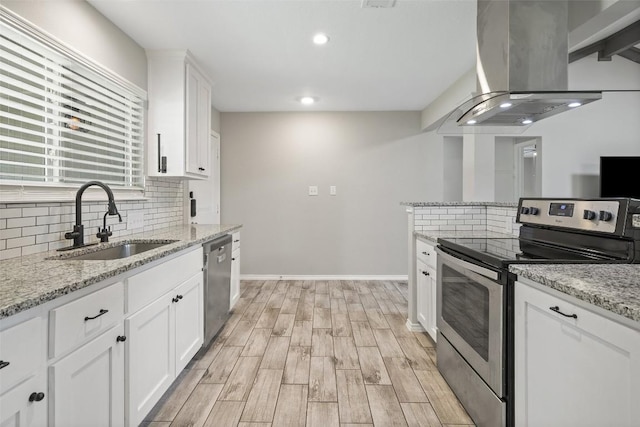 510 Heather Dr, Round Rock, TX 78664 - kitchen featuring appliances with stainless steel finishes, island range hood, backsplash, white cabinets, and recessed lighting