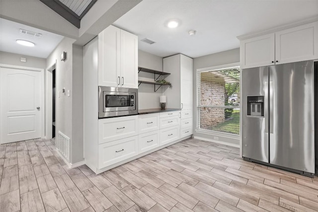 510 Heather Dr, Round Rock, TX 78664 - kitchen featuring appliances with stainless steel finishes, open shelves, light wood-style floors, and white cabinets