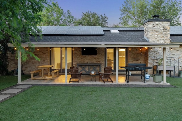 510 Heather Dr, Round Rock, TX 78664 - back of house featuring a chimney, a lawn, solar panels, and stone siding