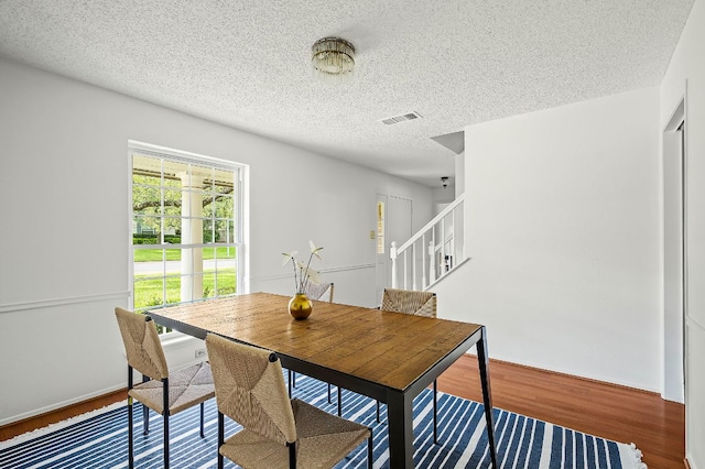 4009 Cordova Dr, Austin, TX 78759 - dining room featuring wood finished floors, a textured ceiling, and stairs