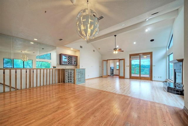 6605 Ladera Norte, Austin, TX 78731 - unfurnished living room with a chandelier, wood finished floors, a ceiling fan, a tile fireplace, and high vaulted ceiling