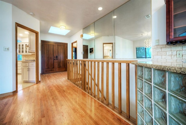 6605 Ladera Norte, Austin, TX 78731 - hallway with a skylight, light wood finished floors, an upstairs landing, and recessed lighting
