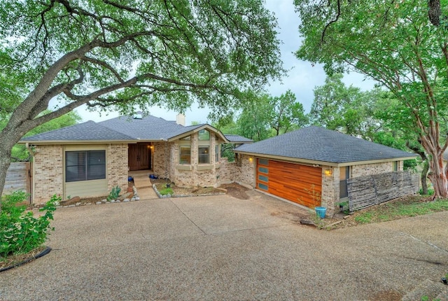 6605 Ladera Norte, Austin, TX 78731 - view of front of house with a chimney, brick siding, a garage, and roof with shingles