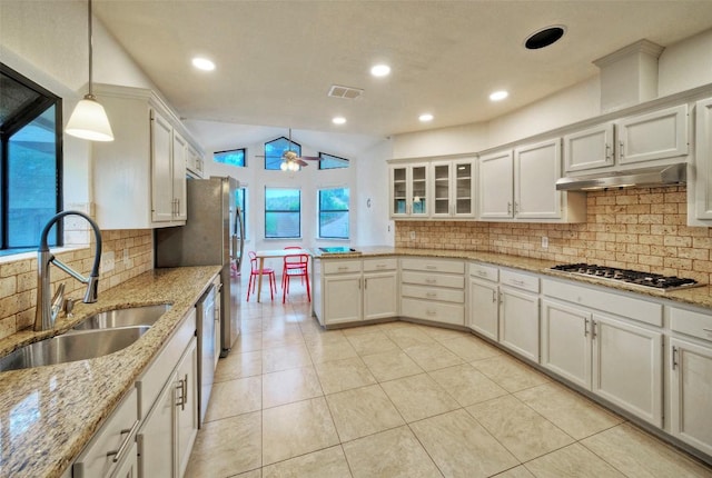 6605 Ladera Norte, Austin, TX 78731 - kitchen featuring stainless steel appliances, a peninsula, under cabinet range hood, decorative backsplash, and lofted ceiling