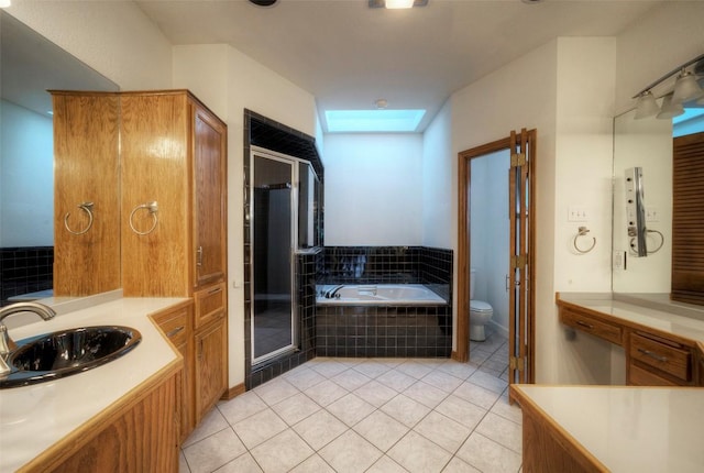 6605 Ladera Norte, Austin, TX 78731 - bathroom featuring a skylight, tile patterned flooring, a bath, a shower stall, and vanity