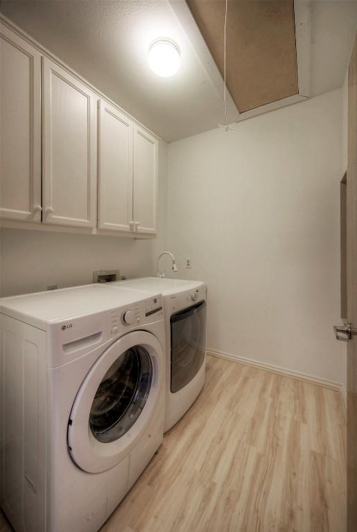 6605 Ladera Norte, Austin, TX 78731 - laundry room with cabinet space, washer and clothes dryer, light wood finished floors, and attic access