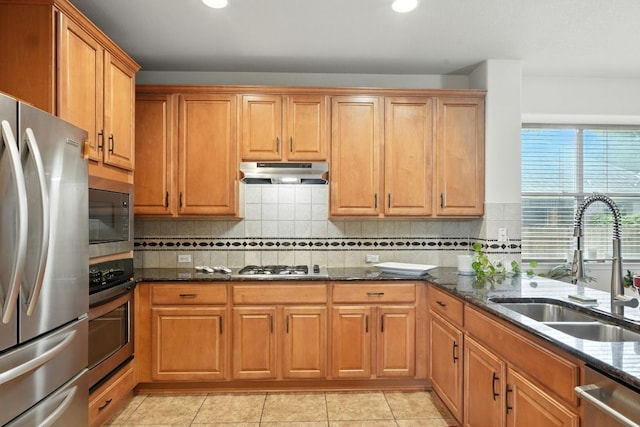 1802 Misty Ridge Dr, Leander, TX 78641 - kitchen with appliances with stainless steel finishes, under cabinet range hood, dark stone counters, recessed lighting, and decorative backsplash