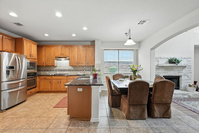 1802 Misty Ridge Dr, Leander, TX 78641 - kitchen with stainless steel appliances, under cabinet range hood, backsplash, light tile patterned floors, and a peninsula