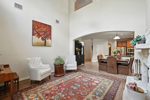1802 Misty Ridge Dr, Leander, TX 78641 - living area featuring arched walkways, a high ceiling, and light wood-style flooring