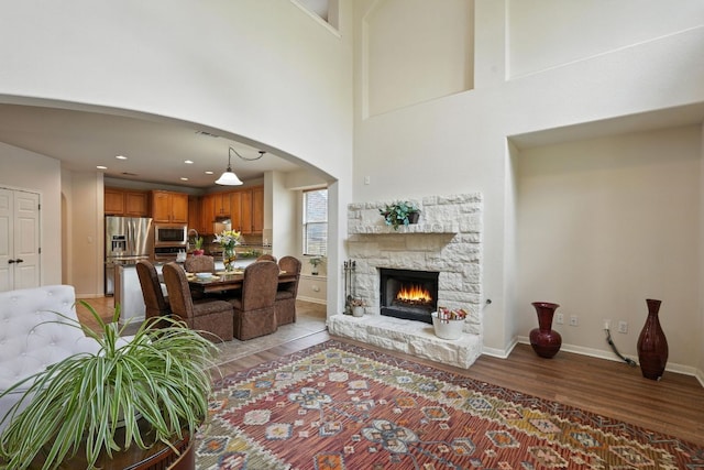 1802 Misty Ridge Dr, Leander, TX 78641 - living area with light wood-style flooring, a fireplace, a high ceiling, arched walkways, and recessed lighting