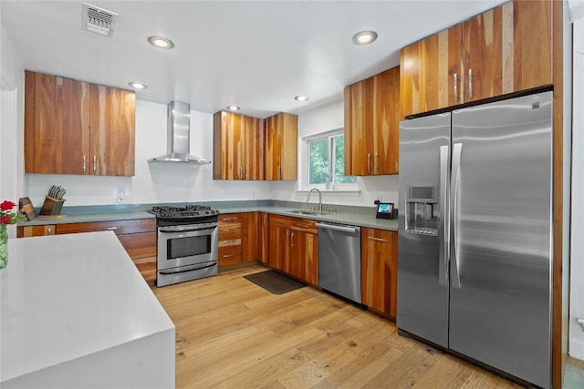 1407 Spring Gdn, Austin, TX 78746 - kitchen with stainless steel appliances, wall chimney exhaust hood, brown cabinets, light wood-style floors, and light countertops