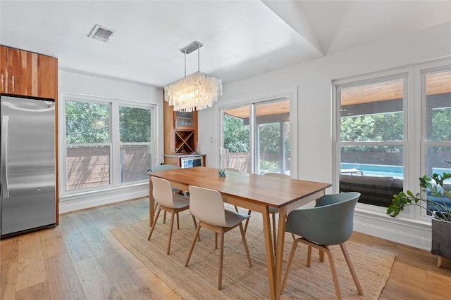 1407 Spring Gdn, Austin, TX 78746 - dining space featuring healthy amount of natural light, a chandelier, and light wood finished floors