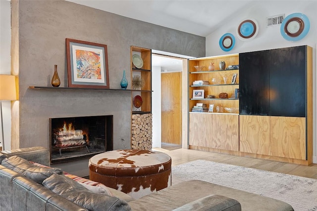 1407 Spring Gdn, Austin, TX 78746 - living room featuring wood finished floors and a lit fireplace